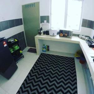 a kitchen with a black and white rug on the floor at Muslim Boutique Apartment with Balcony in Tanah Rata