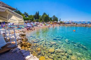 a beach with a bunch of people in the water at Apartment Njivice 5398a in Njivice