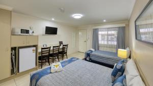 a hotel room with two beds and a kitchen at Chinchilla White Gums Motor Inn in Chinchilla
