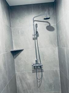 a shower with a shower head in a bathroom at Nyibaer studio apartment in Selfoss