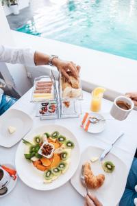 a table with plates of food next to a pool at Papagayo Beach Resort in Willemstad