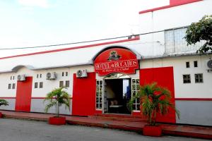a red and white restaurant with palm trees in front of it at Comodas Habitaciones Hotel Bucaros in El Espinal