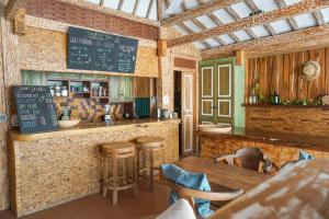 un restaurant avec un bar doté d'une table et de tabourets dans l'établissement Jawa House Private Villas, à Gili Trawangan