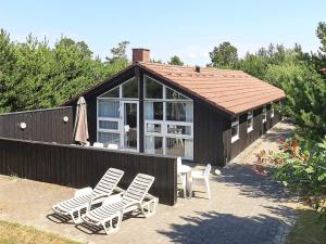 un grupo de sillas y una casa con techo en Three-Bedroom Holiday home in Blåvand 87, en Blåvand