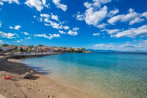 a beach with people laying on the sand and the water at Apartments with a parking space Vantacici, Krk - 5425 in Vantačići