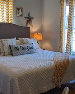 a bed with a be but guest pillow on it at Pecan St. Parlor Haus Downtown Bandera, TX in Bandera