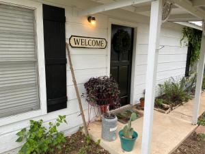 a welcome sign on the front door of a house at Pecan St. Parlor Haus Downtown Bandera, TX in Bandera