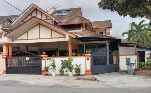 una casa con piante in vaso davanti di Comfortable Private Swimming Pool Homestay Melaka 20 Pax 5R3B a Malacca
