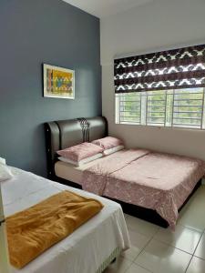 a bedroom with two beds and a window at Muslim Boutique Apartment with Balcony in Tanah Rata