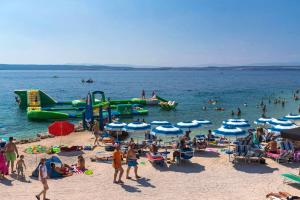 a group of people on a beach with water slides at Apartments by the sea Dramalj, Crikvenica - 5597 in Dramalj +9 photos