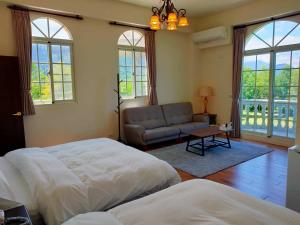 una camera con letto, divano e finestre di 谷築石苑 a Fengli
