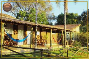 a house with hammocks in front of it at Pousada Serrana in Delfinópolis