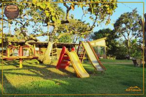 a playground with a slide in a park at Pousada Serrana in Delfinópolis