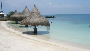 a group of straw umbrellas on a beach at Cabaña la Isla-Coveñas in Coveñas