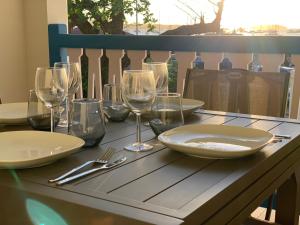 a table with wine glasses and plates on it at Duplex Cosy au cœur de Marigot in Marigot