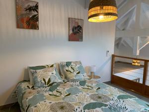 a bedroom with a bed with a flowered blanket at Duplex Cosy au cœur de Marigot in Marigot