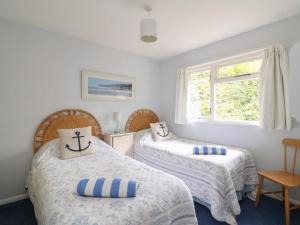 a bedroom with two beds and a window at Woodlands Cottage in Dorchester