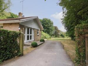 a house with a driveway next to a building at Woodlands Cottage in Dorchester