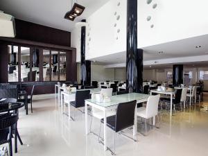 a dining room with white tables and chairs at MD Grand Hotel Nakhon in Nakhon Si Thammarat