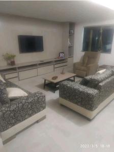 uma sala de estar com 2 sofás e uma televisão de ecrã plano em Excelente casa com Piscina em Camaçari