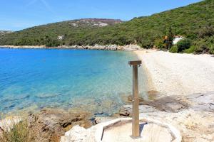 un poste en una playa junto al agua en Holiday house with WiFi Ustrine, Cres - 8037, en Ustrine 12 fotos más