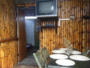 um quarto com uma mesa com cadeiras e uma televisão em CABAÑAS ECOLOGICAS STEPHANIE JIRETH em Tonsupa