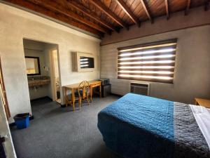 Schlafzimmer mit einem Bett, einem Schreibtisch und einem Fenster in der Unterkunft Hotel Paris in Tijuana