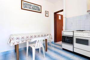 a kitchen with a table and a table and chairs at Apartments by the sea Kabli, Peljesac - 10225 in Brijesta