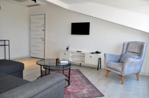 a living room with a couch and a table and a tv at MAT BOUTIQUE HOTEL in Çeşme