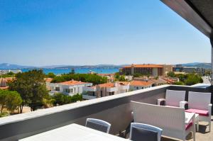 a balcony with chairs and a view of a city at MAT BOUTIQUE HOTEL in Çeşme