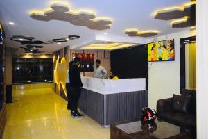 two men standing at a bar in a restaurant at Hotel Grand Residency in Jamshedpur