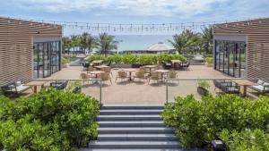 a patio with tables and chairs and stairs at Wyndham Garden Cam Ranh Resort in Cam Ranh