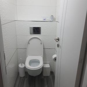 een kleine badkamer met een toilet met deksel omhoog bij Lovely three-room apartment above the promenade in Ashdod