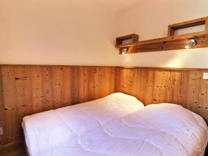 a bed in a room with wood paneled walls at Appartement La Tania, 2 pièces, 6 personnes - FR-1-182A-4 in Courchevel