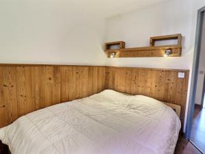 Appartement La Tania, 2 pièces, 6 personnes - FR-1-182A-7 في كورشوفيل: غرفة نوم بسرير مع جدار خشبي