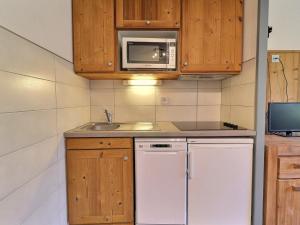een keuken met een witte koelkast en een magnetron bij Appartement La Tania, 2 pièces, 4 personnes - FR-1-182A-27 in Courchevel
