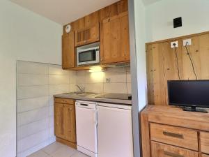 een kleine keuken met een koelkast en een magnetron bij Appartement La Tania, 2 pièces, 4 personnes - FR-1-182A-27 in Courchevel