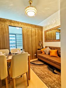- une salle à manger avec une table et un canapé dans l'établissement Stylish 1 Bedroom Condo Unit with Perfect Pool View Balcony at Fame Residences, à Manille