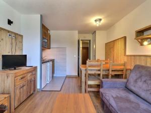 een woonkamer en een keuken met een bank en een tafel bij Appartement La Tania, 2 pièces, 4 personnes - FR-1-182A-31 in Courchevel