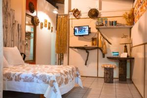- une chambre avec un lit et une télévision murale dans l'établissement Douceur Tropicale Proximité plage et commerces, à Punaauia