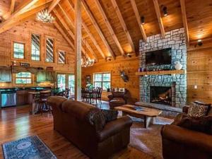 ein Wohnzimmer mit Sofas und einem Steinkamin in der Unterkunft Luxury lodge in the heart of the Bluegrass 