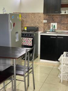 a kitchen with a table and a refrigerator at Apartamento CERCA AEROPUERTO, Fotos y huellas para visa americana, embajada EEUU in Bogotá