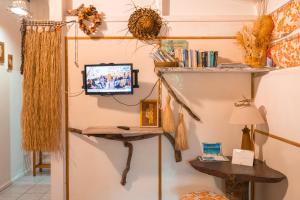 a living room with a tv on a wall at Douceur Tropicale Proximité plage et commerces in Punaauia