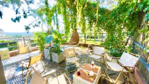 昆明市にあるクンミン アップランド インターナショナル ユース ホステルの木々が植わるパティオ(椅子、テーブル付)