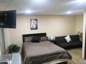 a bedroom with a bed and a couch at FAKALI Homestay in Quito
