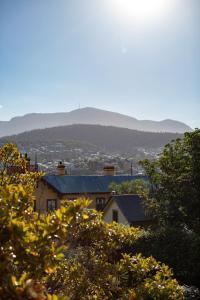 uma casa no topo de uma colina com árvores em The Corinda Collection em Hobart