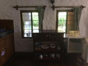 a kitchen with two windows and a counter top at Diani Banda Cottages in Diani Beach