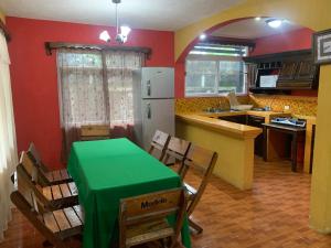 cocina con mesa, sillas y nevera en Casa 3 a 5 min del Irtra, en Retalhuleu