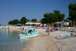 a group of people on a beach with a boat at Family friendly apartments with a swimming pool Tribalj, Crikvenica - 14789 in Tribalj