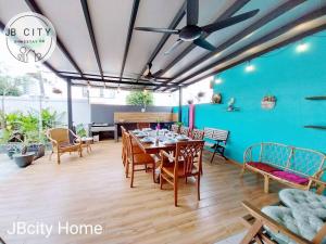 comedor con mesa, sillas y pared azul en KIM Hideko Villa by JBcity Home, en Johor Bahru